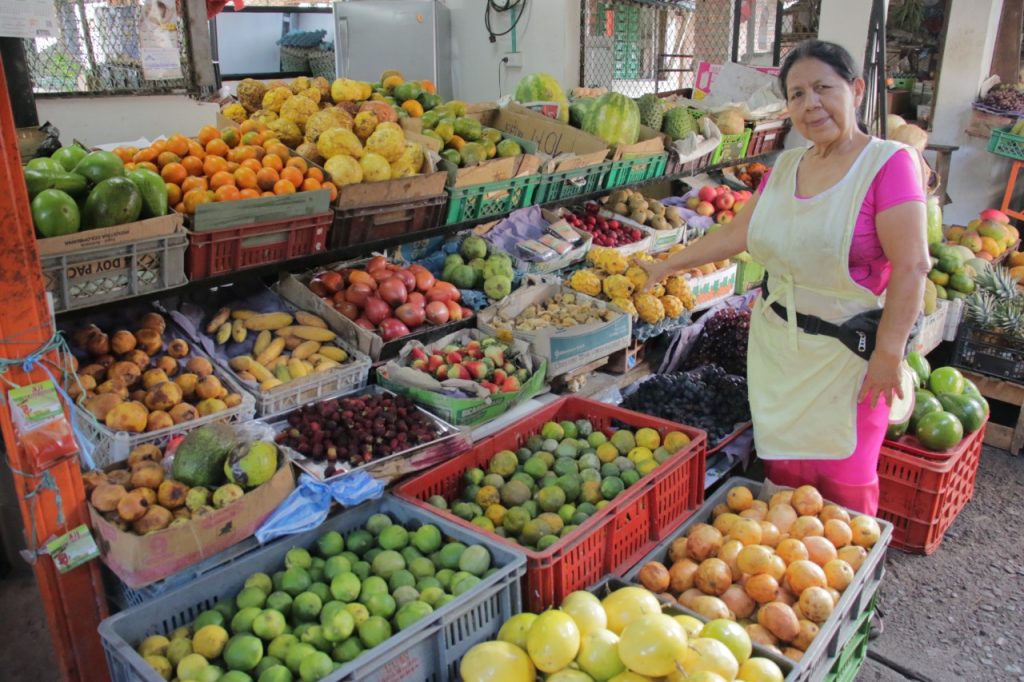 mujer con su puesto de ventas de frutas