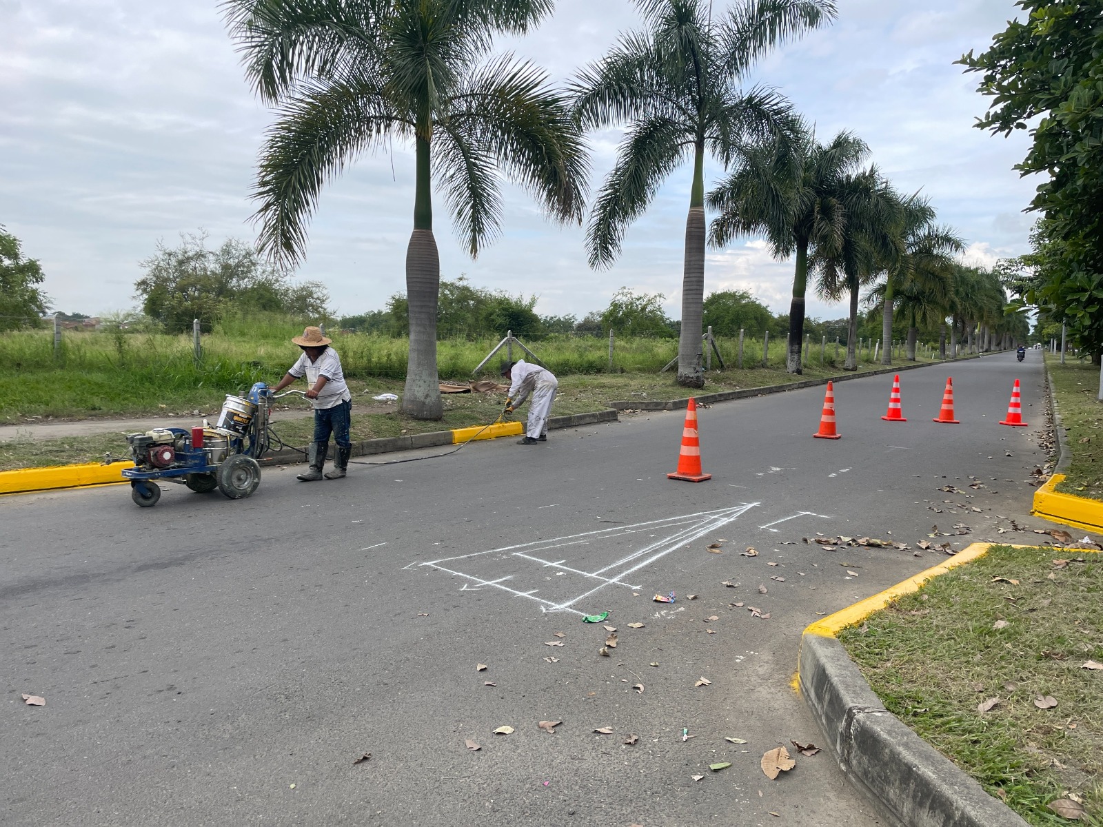 dos operarios señalizando con pintura la via