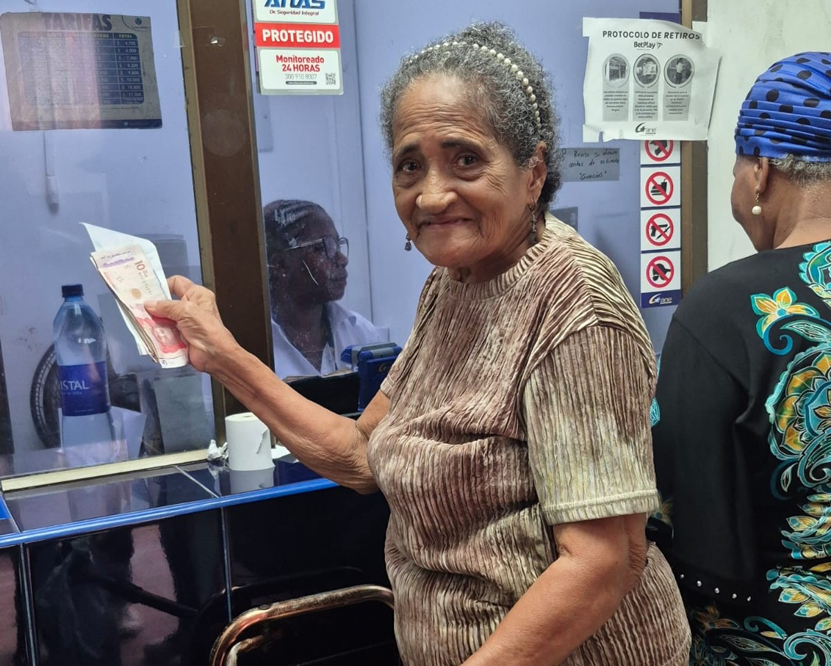 adulta mayor recibiendo subsidio en ventanilla