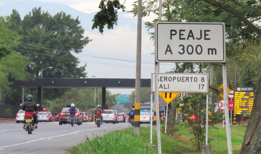 Señal de tránsito que indica un peaje a 300 metros en una carretera concurrida hacia Cali, Colombia