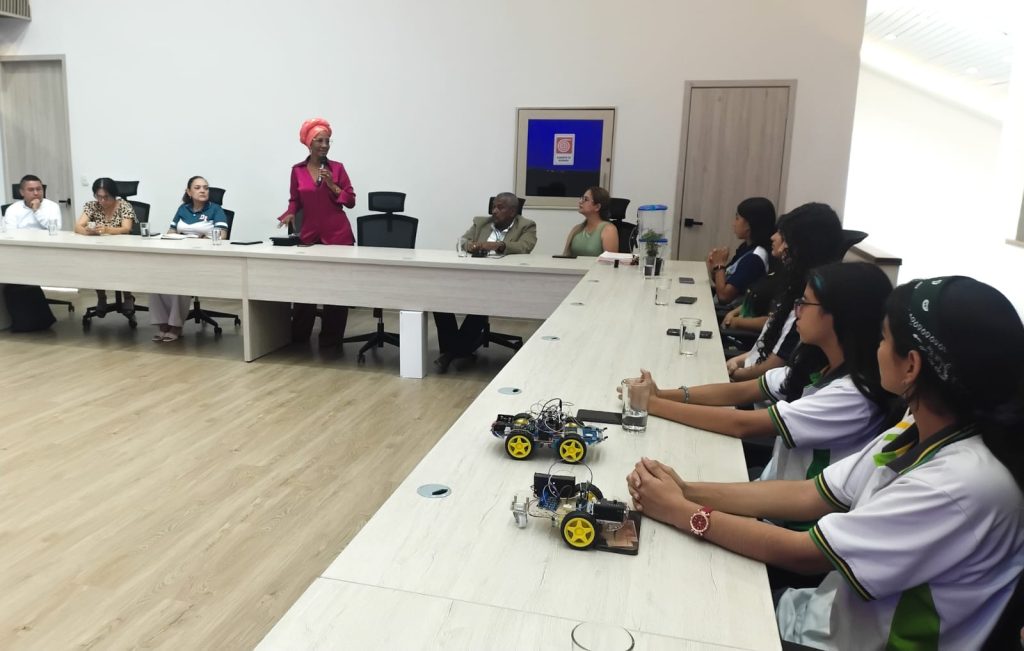 Reunión en la Alcaldía de Palmira entre autoridades locales y jóvenes estudiantes que presentan proyectos de robótica sobre una mesa