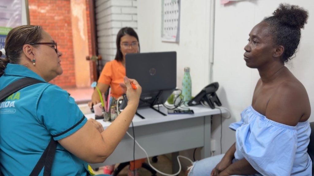 Una servidora pública de salud de Palmira brinda orientación personalizada a una ciudadana en una oficina institucional.