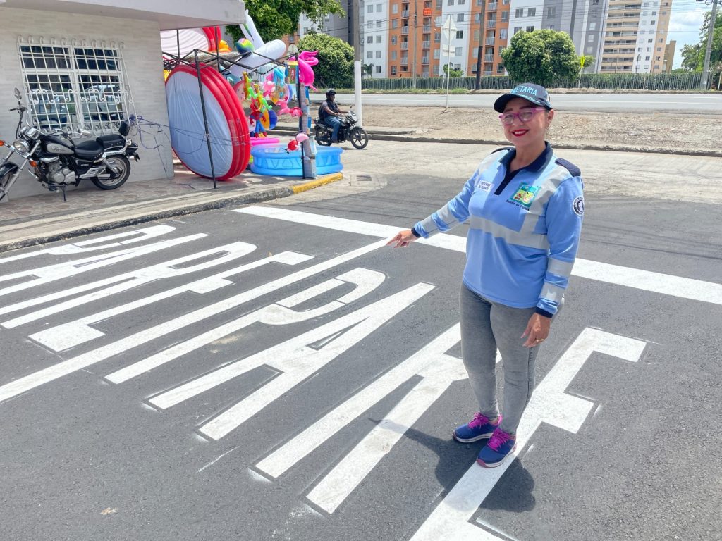 Secretaría de Tránsito con uniforme de movilidad señalando la nueva señalización vial de 'PARE' en una calle