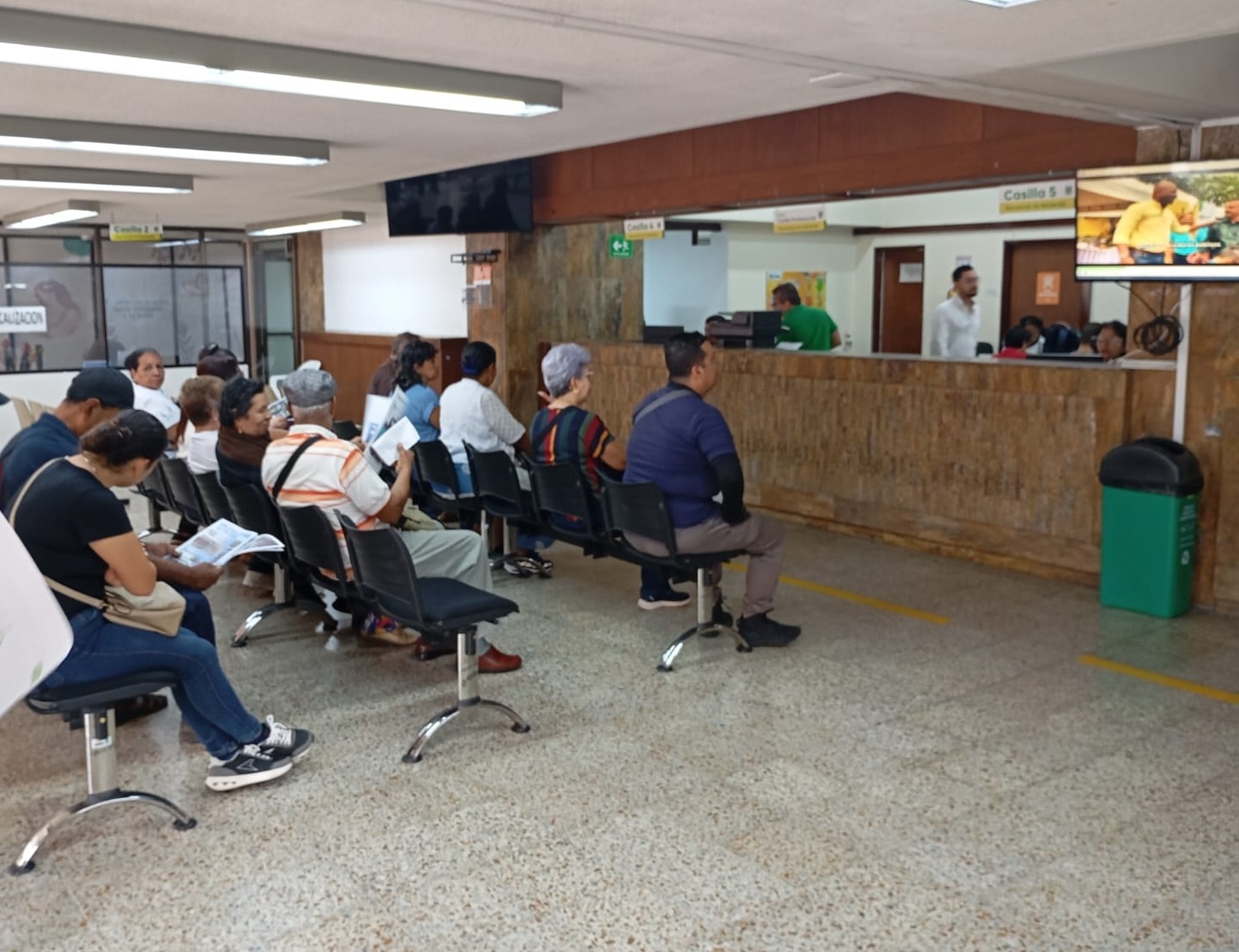 Ciudadanía de Palmira sentada en una sala de espera mientras recibe atención en las ventanillas de una oficina de la administración municipal