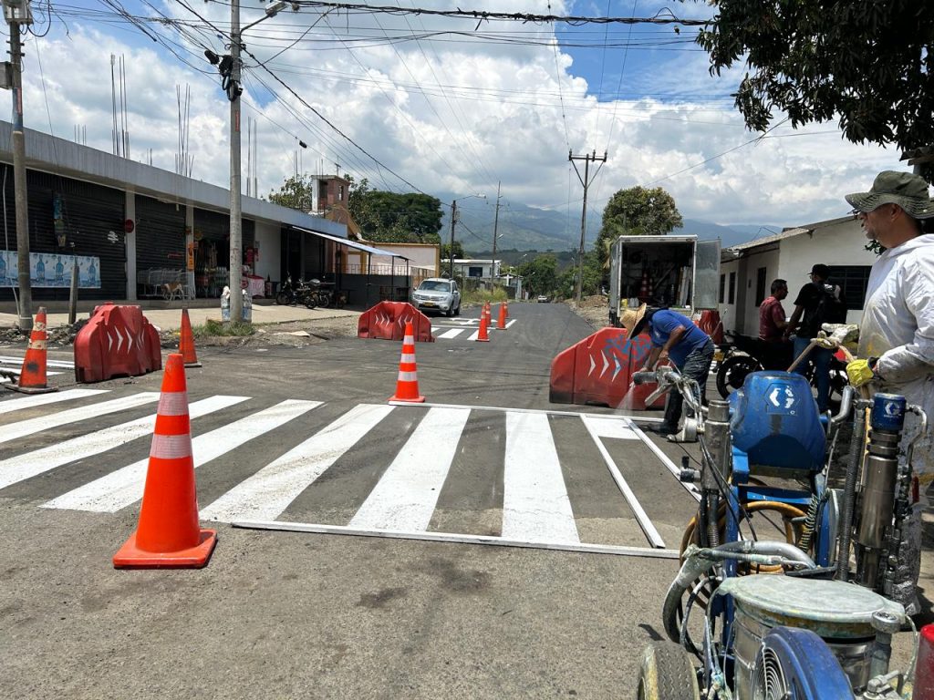 Personal de la Alcaldía de Palmira señalizando un paso peatonal con pintura blanca y maquinaria especializada en una calle de la ciudad