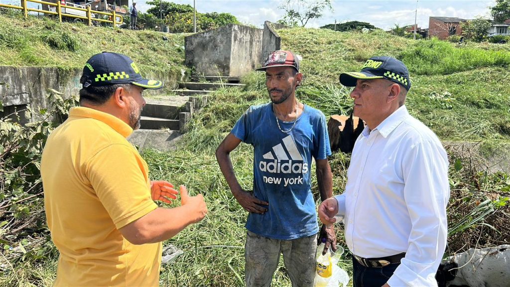 Integrantes del equipo de la Alcaldía de Palmira dialogan con un ciudadano en una zona verde durante una jornada de intervención y limpieza en un sector del municipio