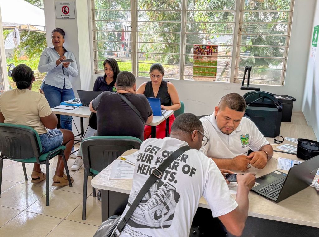 Equipo de trabajo Agencia Pública de Empleo con personal técnico atienden a la población con discapacidad auditiva en mesas de registro con computadoras portátiles.