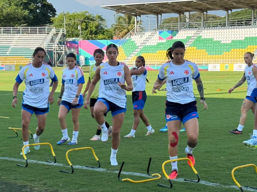 Integrantes de la Selección Colombia Femenina de Fútbol realizan ejercicios de salto y coordinación sobre pequeñas vallas amarillas durante un entrenamiento en el estadio Rivera Escobar de Palmira