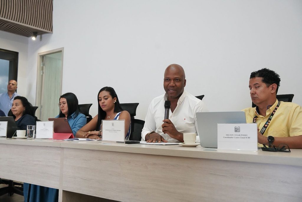 Fotografía de una mesa directiva en una reunión de la Alcaldía de Palmira. En el centro, el alcalde Víctor Ramos habla por micrófono, acompañado por tres mujeres y dos hombres que atienden la sesión de trabajo