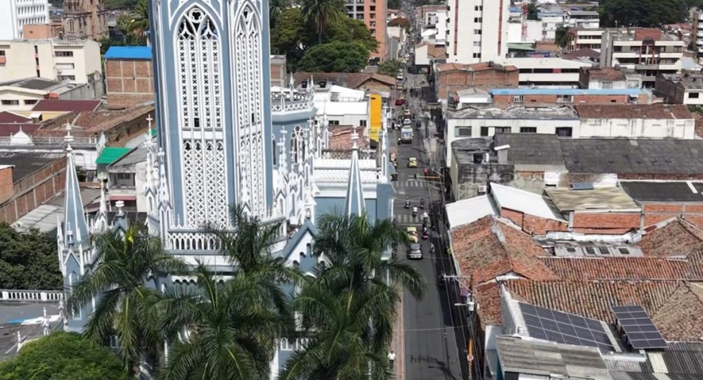 Vista aérea de la torre gótica azul de la catedral de Palmira junto a una calle transitada del centro urbano.