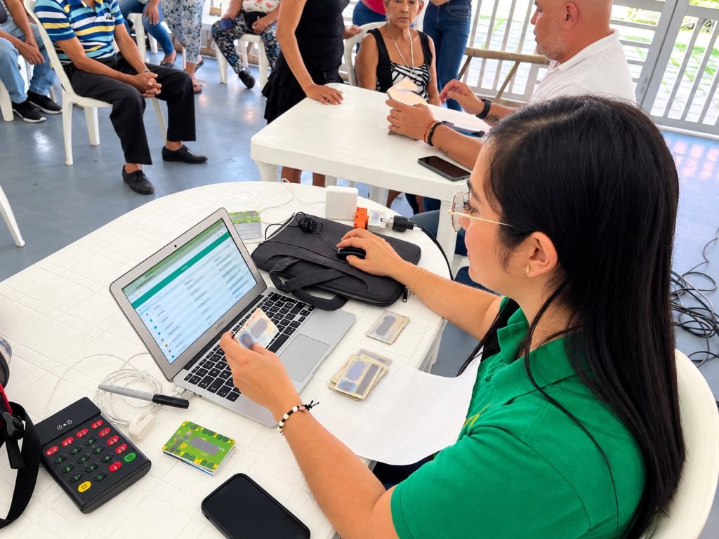 En la foto Una funcionaria de la Secretaría de Tránsito verifica un documento de identidad frente a una computadora portátil en una mesa de atención ciudadana.