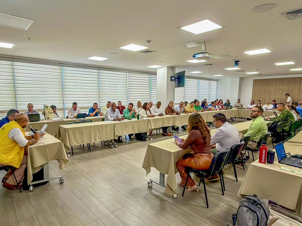 Reunión en un salón de eventos con mesas dispuestas en forma de U donde funcionarios y asistentes participan en la primera sesión de la Comisión del Ministerio Público de Seguimiento a la Respuesta Rápida a las Alertas Tempranas