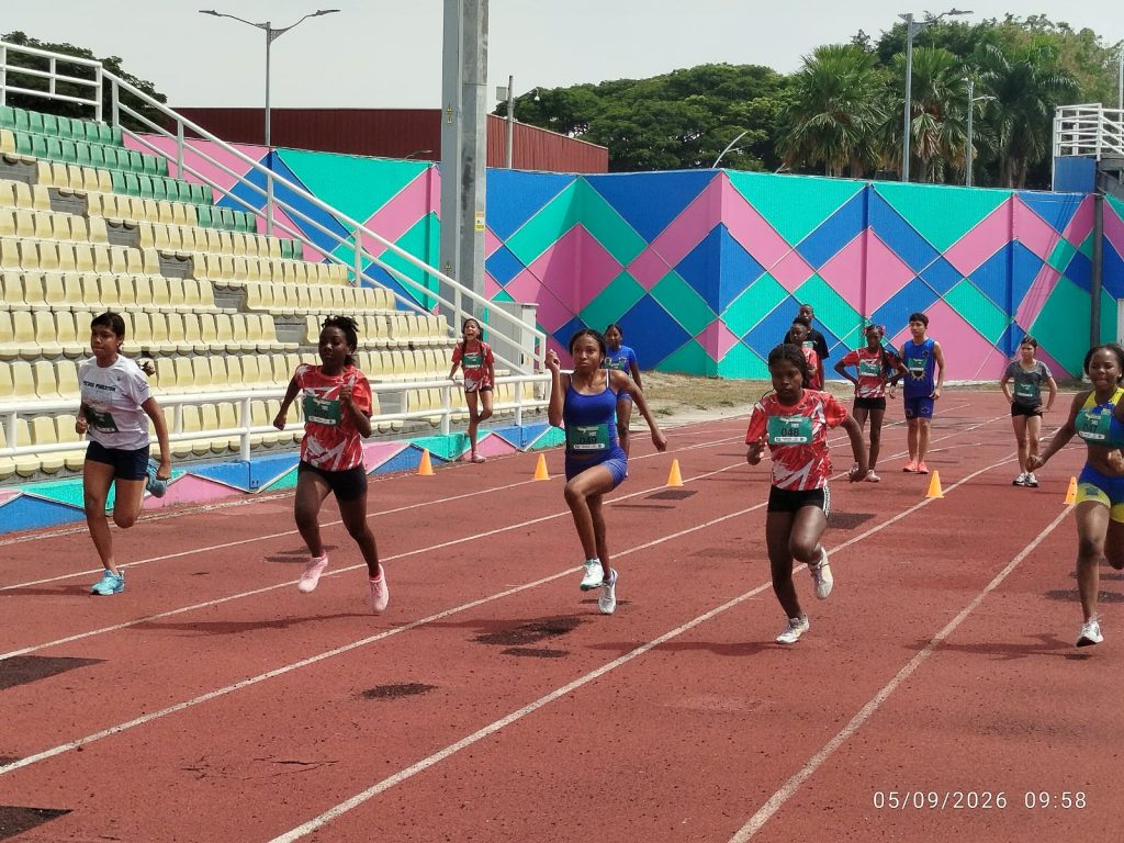 En la fotografia Grupo de jóvenes atletas compitiendo en una carrera de velocidad sobre una pista de atletismo.