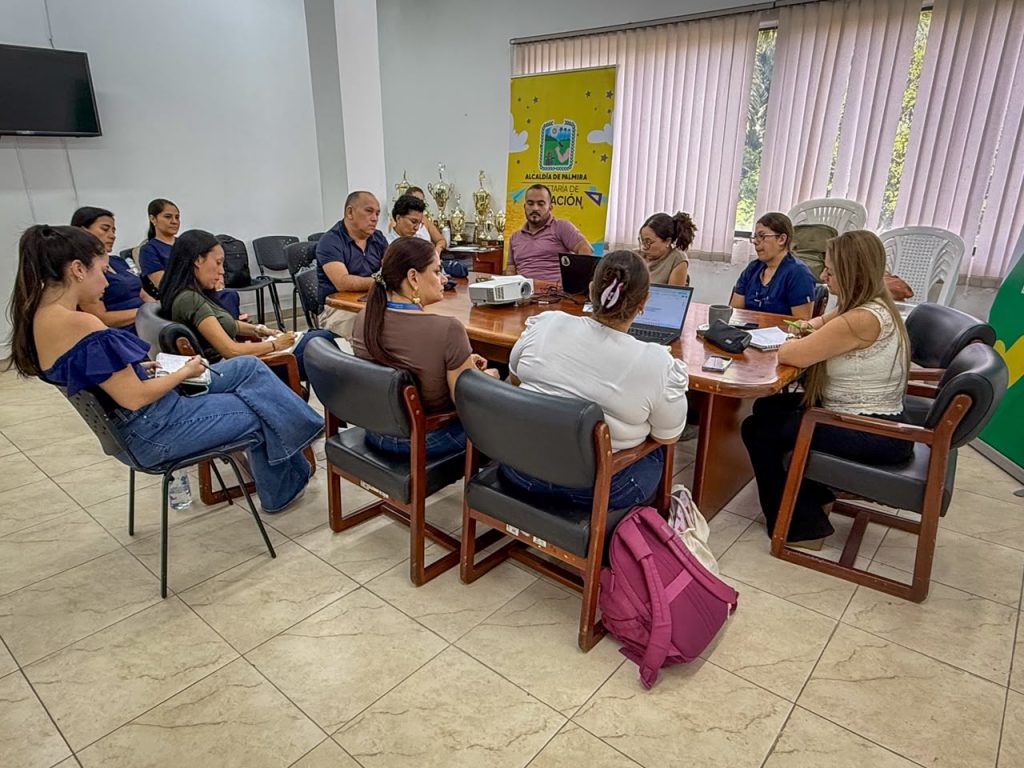 En la foto un grupo interdisciplinario de docentes y profesionales en educación analiza documentos y datos en computadores durante una mesa de trabajo institucional.